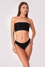 Model wearing a black JUA NUR lingerie set on a white background