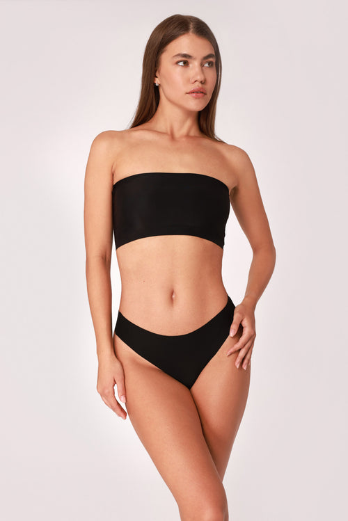 Model wearing a black JUA NUR lingerie set on a white background