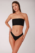 Model wearing a black JUA NUR lingerie set against a plain background