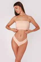 Model wearing a beige JUA NUR lingerie set on a plain background