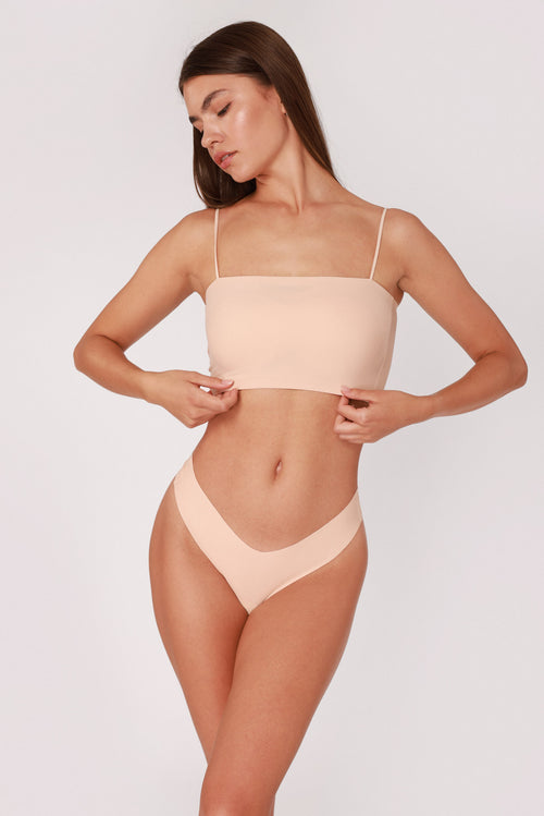 Model wearing a beige JUA NUR lingerie set on a plain background